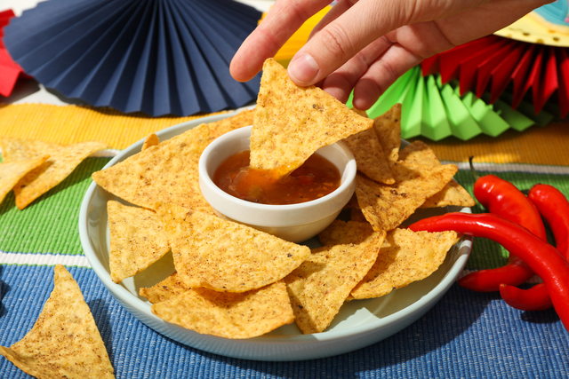 Nachos in a bowl with sauce and festive decorations