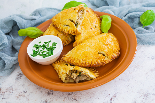 Baked empanadas on white background