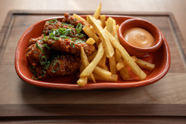 Crispy chicken wings served with golden fries and spicy sauce