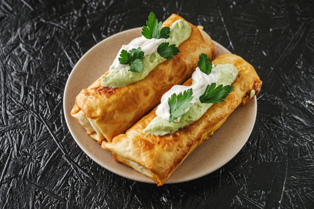 set of delicious fresh colorful deep-fried chimichanga on a dark background